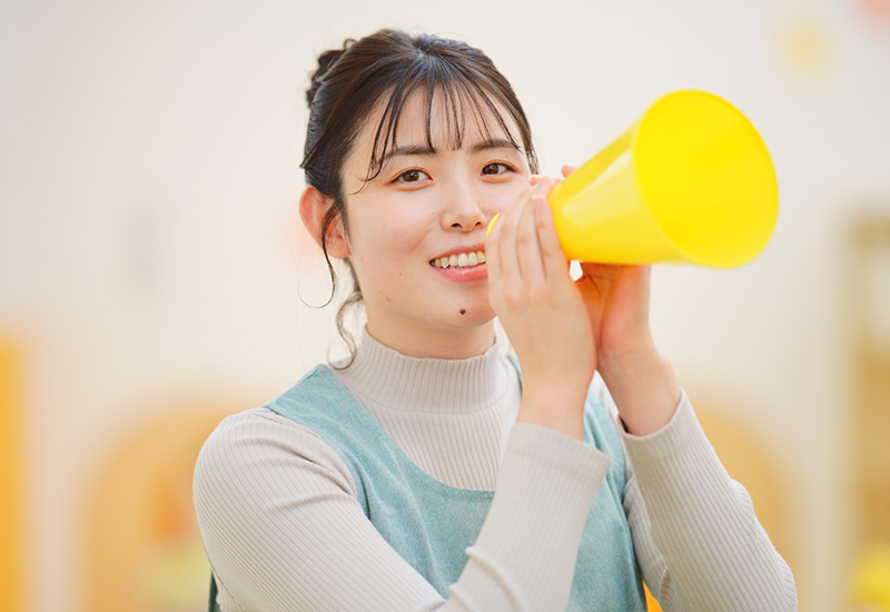 メガホンで子どもたちに呼びかける保育園の先生